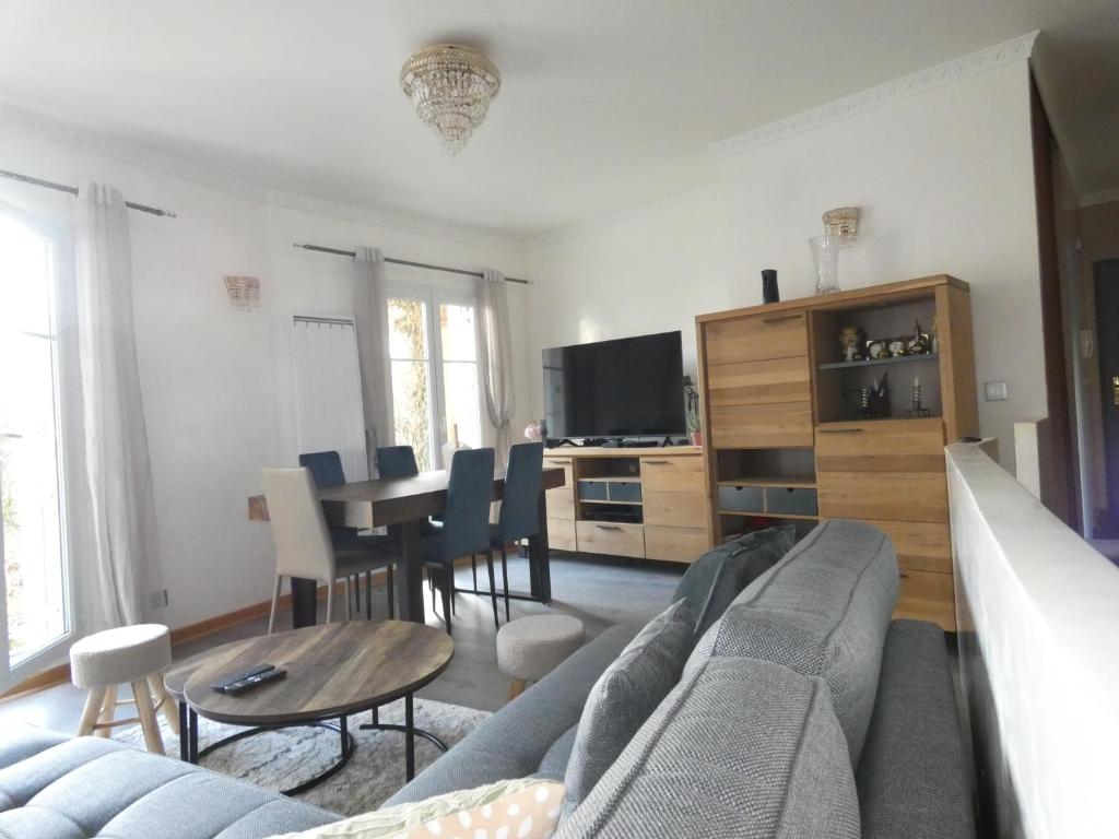 un salon avec un canapé et une table dans l'établissement Appartement spacieux et 5 minutes DISNEY LAND PARIS, à Bailly-Romainvilliers