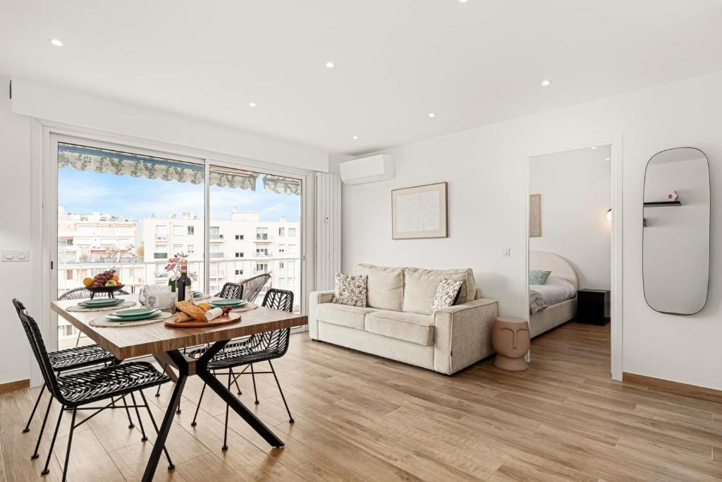 un salon avec une table, des chaises et un canapé dans l'établissement Suite Sérénade - Appartement à Cannes, à Cannes
