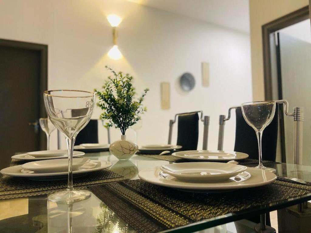 a dining room table with glasses and plates on it at Best house for living in Karachi