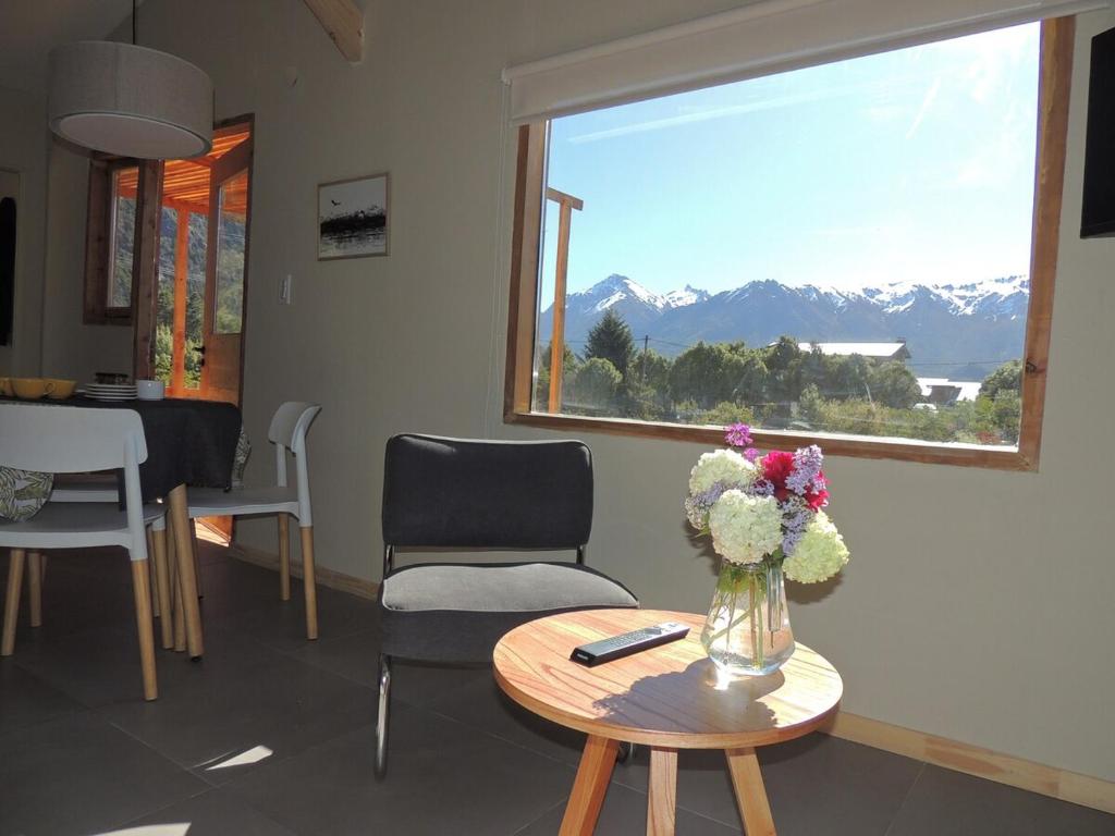 ein Wohnzimmer mit einer Vase mit Blumen auf einem Tisch in der Unterkunft Casa con magnifica vista al Cerro Catedral in San Carlos de Bariloche