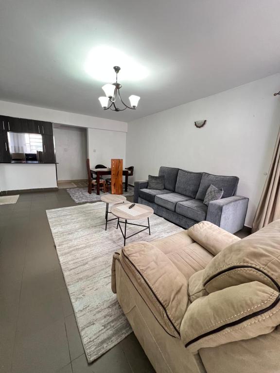 KerichoにあるComfort2 bedrooms in kericho townのソファとテーブルのあるリビングルーム