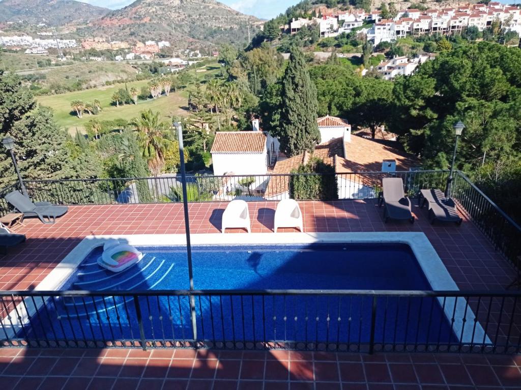 Blick auf einen Swimmingpool vom Balkon eines Hauses in der Unterkunft Apartamento en Villa con Piscina in Málaga