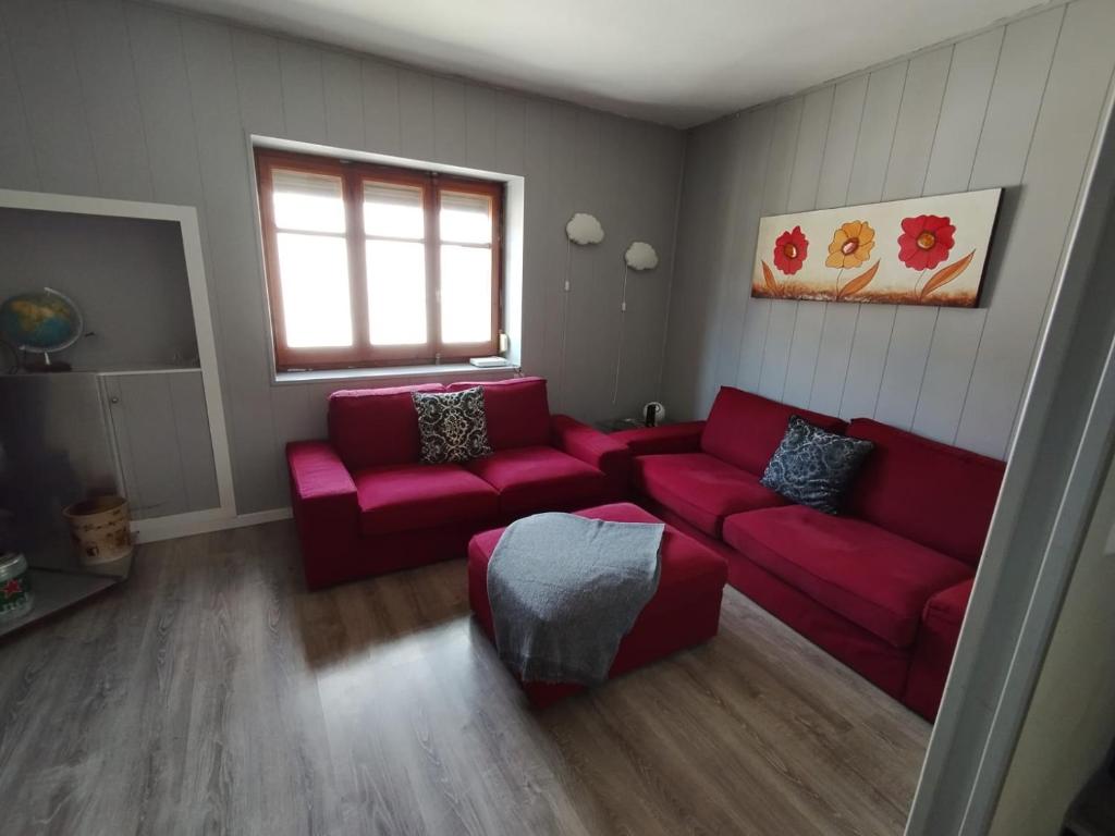 a living room with a red couch and a window at rural relax in Villar del Arzobispo
