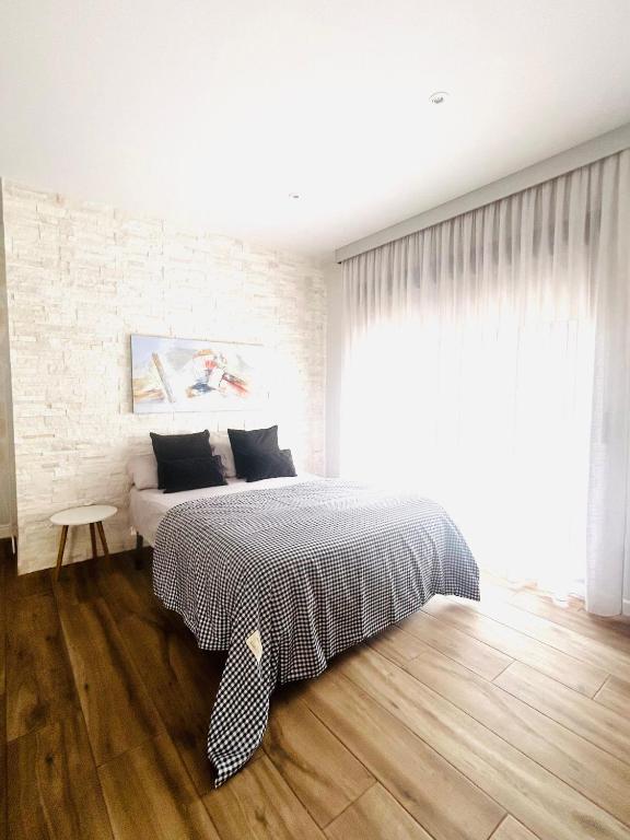Un dormitorio con una cama y una pared de ladrillo. en Apartamento Alfacar, en Alfacar