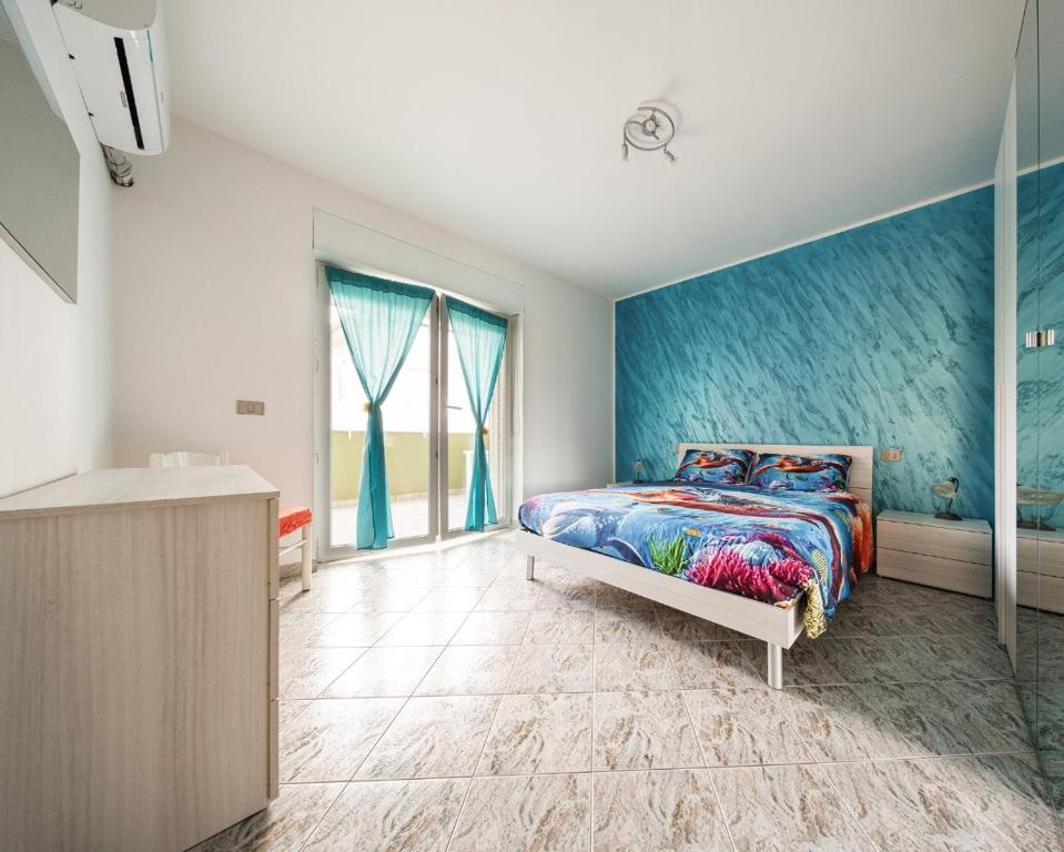 a bedroom with a bed and a blue wall at Bosa Mare & Relax in Bosa Marina