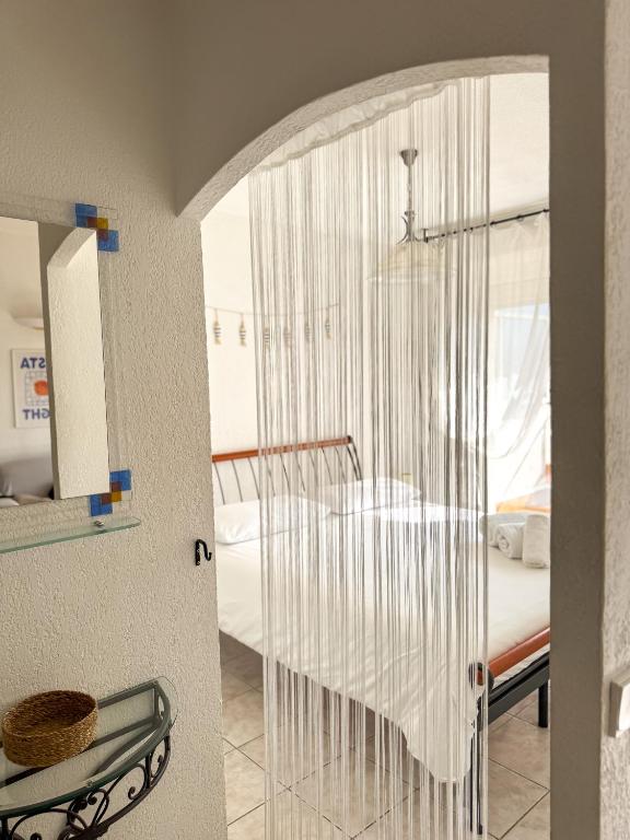 Cette chambre dispose d'un lit et d'une paroi en verre. dans l'établissement Coquet Appartement Avec Le Terrasse Sur Le Mer, à Roquebrune-Cap-Martin