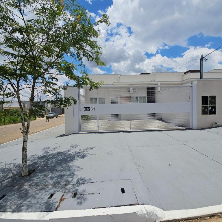 a large white building with a garage at Casa Nova 01 in Primavera do Leste