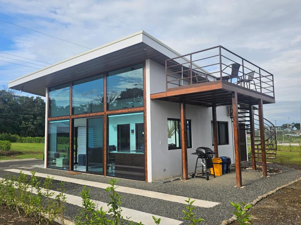 a small house with a balcony and a deck at Casa Tigrillo - La Fortuna in Agua Azul
