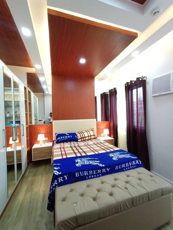a bedroom with a large bed with a blue blanket at B&M Rental- Antara in San Isidro