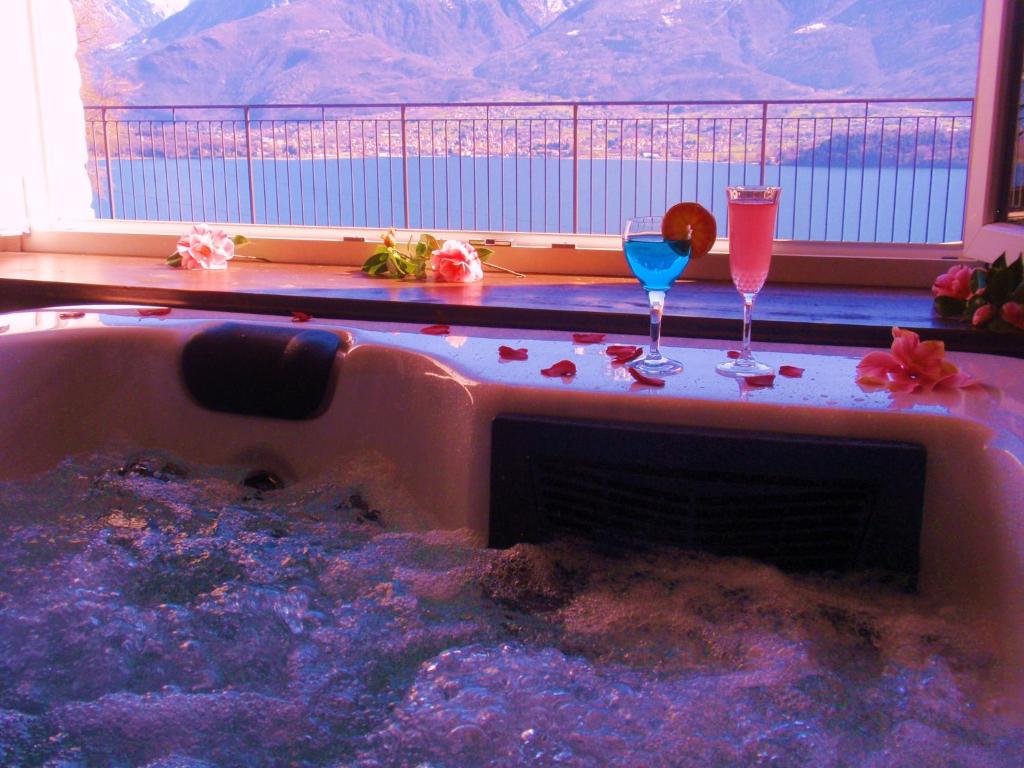 a hot tub with two cocktails and two glasses at Residence Le Azalee & SPA in Vercana