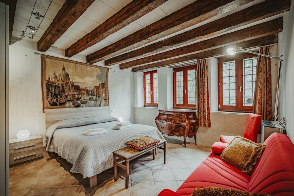 una camera da letto con un letto e un divano rosso di Autentico rifugio veneziano Bilocale nel cuore di Cannaregio a Venezia