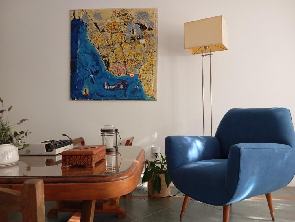 uma sala de estar com uma cadeira azul e uma mesa em Socaire, tu refugio en Chascomús em Chascomús