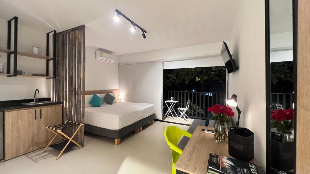 a bedroom with a bed and a table and a kitchen at HOTEL 9.5 SAN FERNANDO in Cali