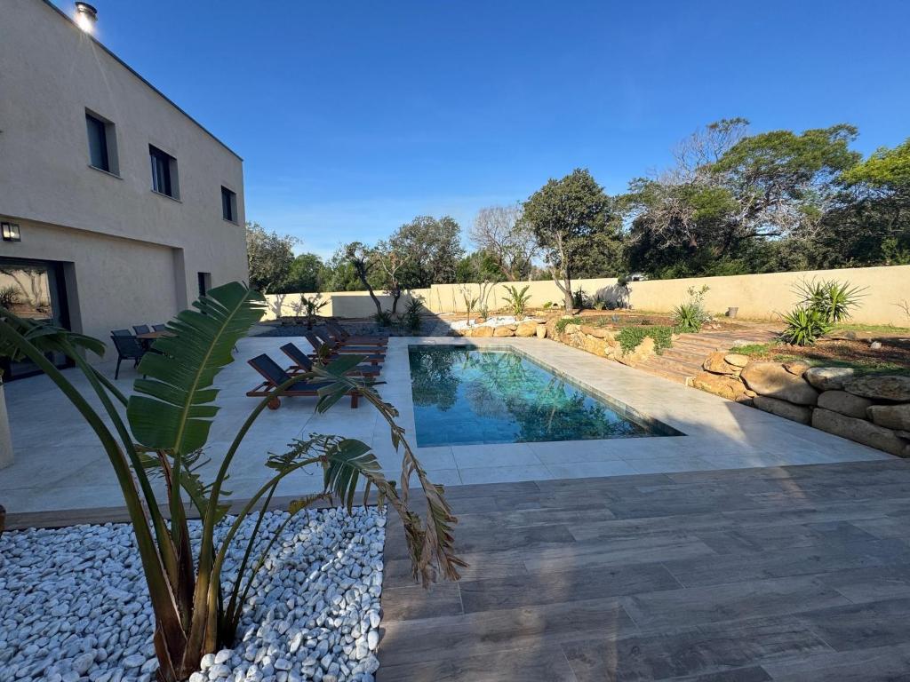 - une piscine dans une cour à côté d'un bâtiment dans l'établissement Villa de standing avec piscine et jacuzzi, à Belgodère