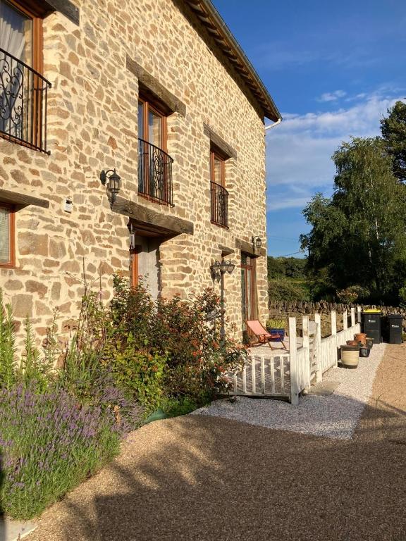un bâtiment avec une clôture blanche à côté d'une maison dans l'établissement La Grange, à Naillat