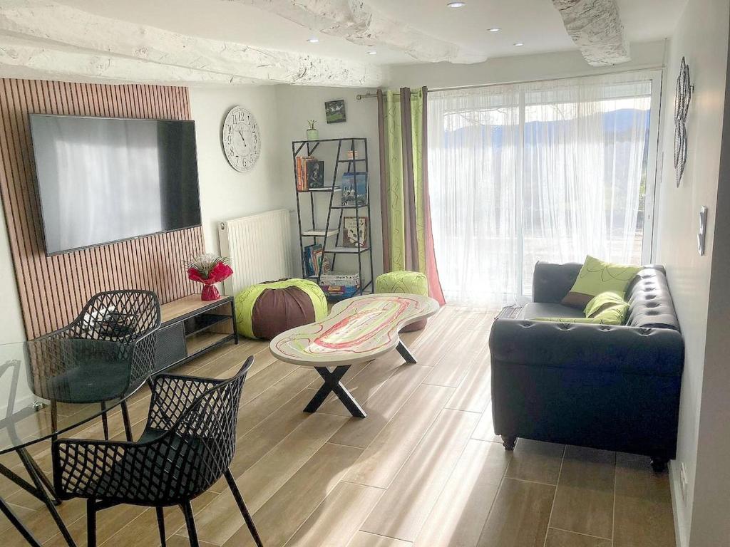 un salon avec un canapé, une table et des chaises dans l'établissement Gite Le Prédaïou 4 personnes, à Montrozier