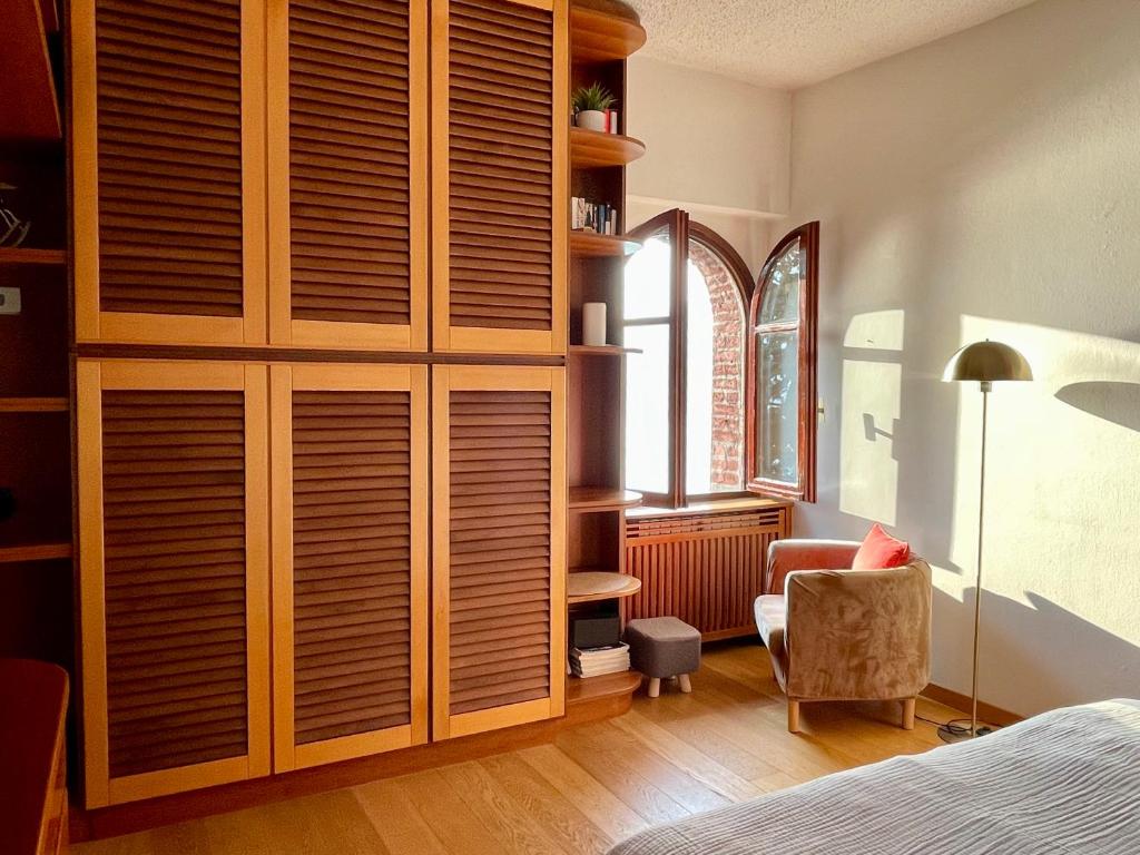 a bedroom with wooden cabinets and a chair and a bed at Lake Front View on Viale GENO in Como