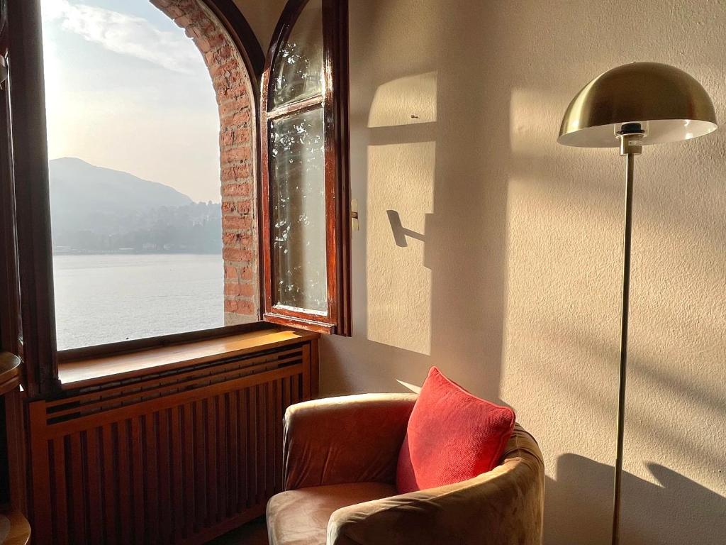 a living room with a chair and a window at Lake Front View on Viale GENO in Como