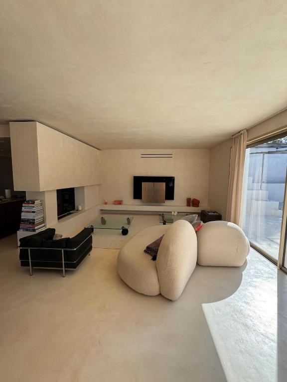 - un salon avec deux chaises blanches et un canapé dans l'établissement Éclat De Provence Villa de Luxe avec Vue Panoramique, Piscine & Proche Calanques, à Allauch