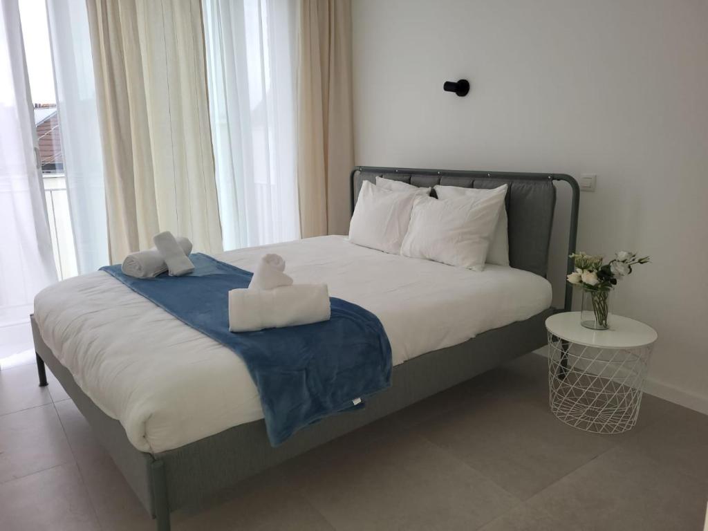 Un dormitorio con una cama con dos animales de peluche encima. en Studio lumineux Bruxelles, en Bruselas