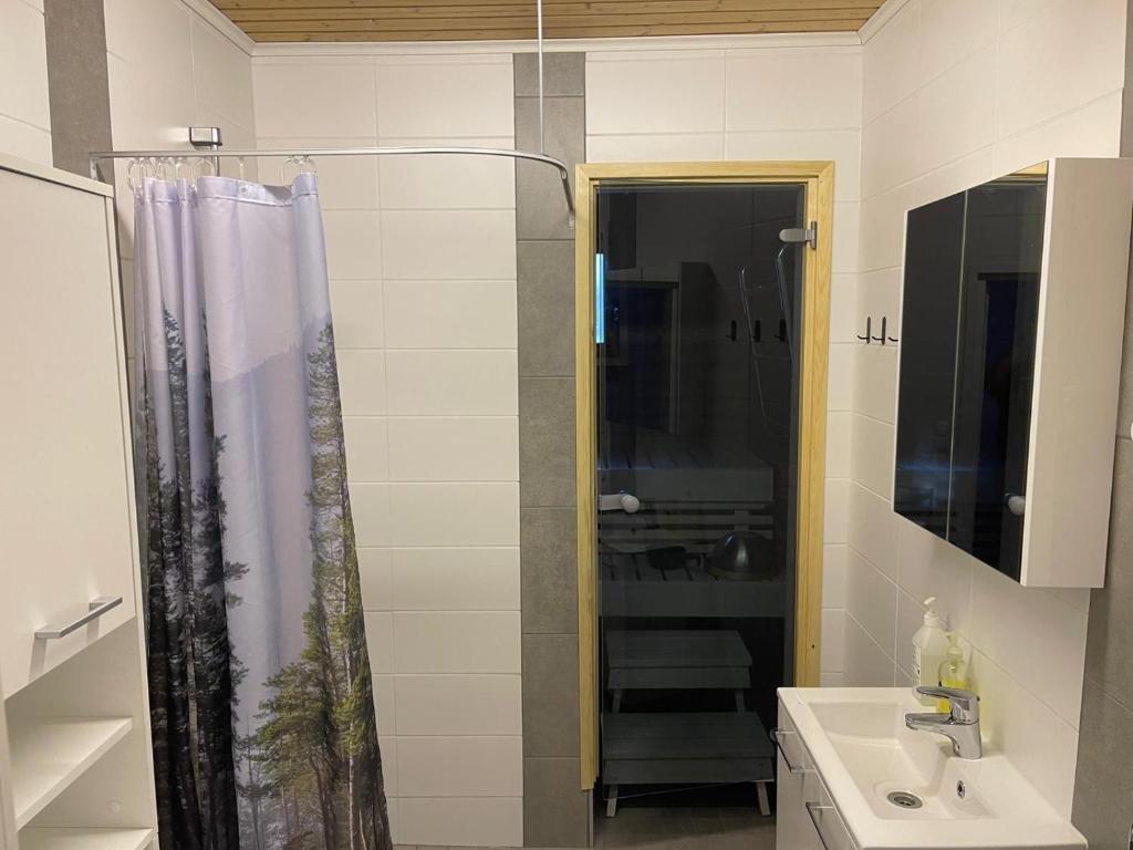 a bathroom with a shower and a sink at Villa Repovesi in Hillosensalmi