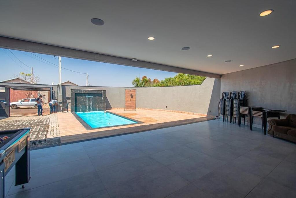 a large living room with a swimming pool in a house at Espaço horizonte verde in Ribeirão Preto