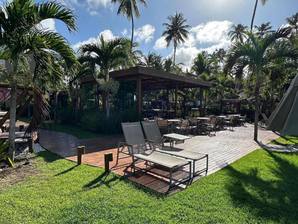 un patio avec des chaises, des tables et un kiosque dans l'établissement Amura Carneiros - Luxo e Sofisticação na Beira-Mar de Carneiros by HM, à Tamandaré