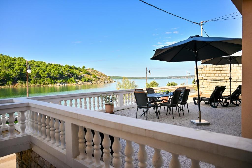 a balcony with a table and chairs and an umbrella at Apartment Bazdaric in Novigrad Dalmatia