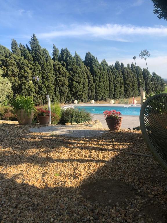 un parc avec un banc et une piscine dans l'établissement Maison viticole dans le Sud de la France avec grand piscine, à Moussan