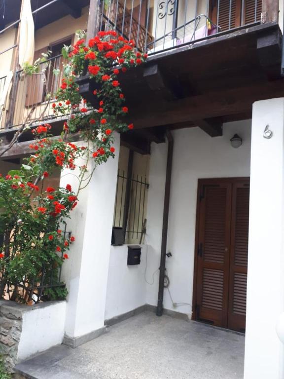 a building with red flowers on the side of it at Borgo incantato in Villar Dora