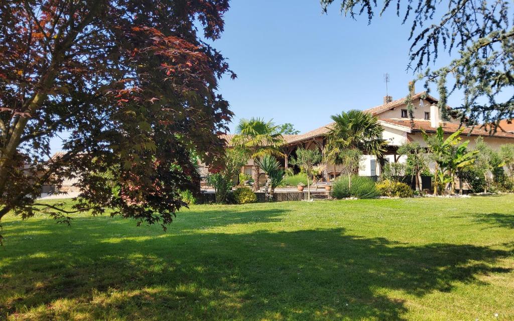 a house in a yard with a green lawn at Chambres d'hotes "Chez Marchio" in Crottet