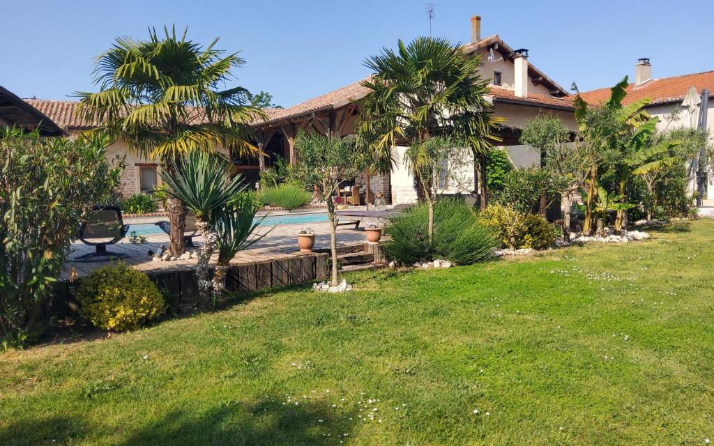 a house with a yard with a pool and palm trees at Chambres d'hotes "Chez Marchio" in Crottet