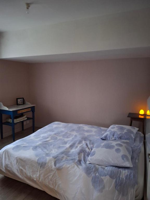 a bedroom with a large bed with blue sheets and pillows at Chambre lit double près de la Loire in La Riotière