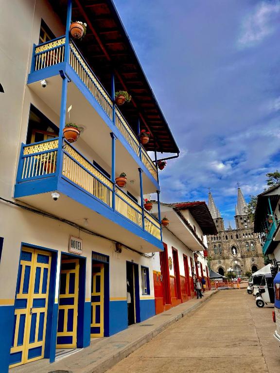 a building with blue and yellow doors and balconies on it at Hotel Dorado Jardín in Jardin