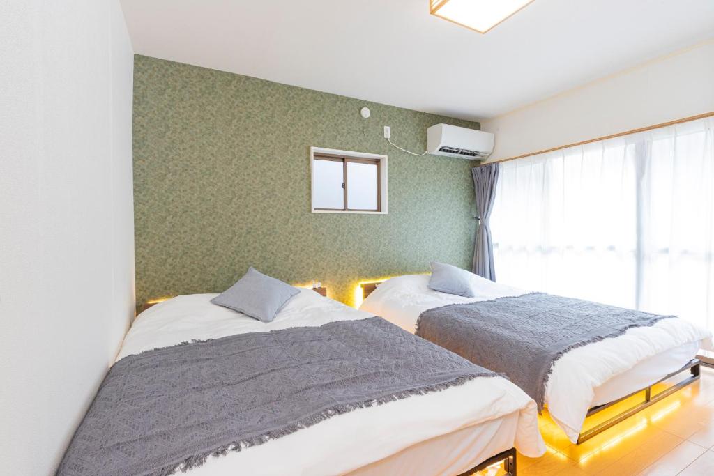 東京にあるZen Home AKABANEのベッド2台と窓のある寝室