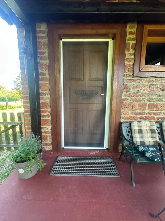 a screened in door to a house with a bench at Cottage Plavi Lav Potok in Potok