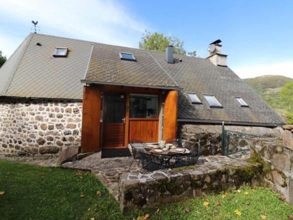a stone house with a table in front of it at Trésors de Lilain in Cheylade