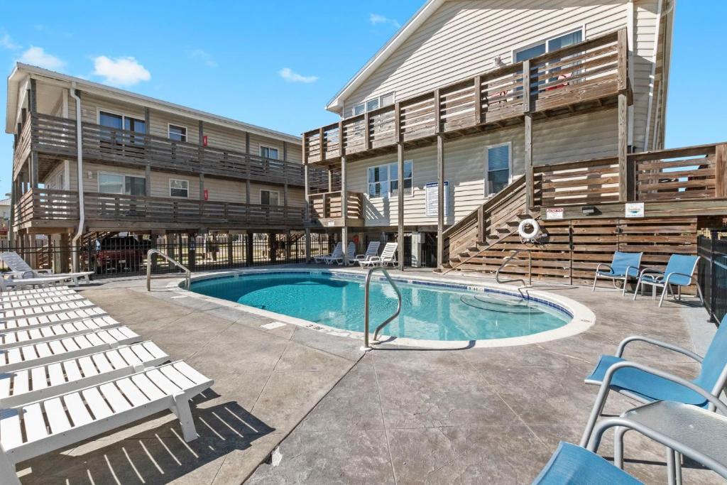 una piscina con sedie e un edificio di 2BR Retreat with Pool, Near Beach and The Hangout a Gulf Shores