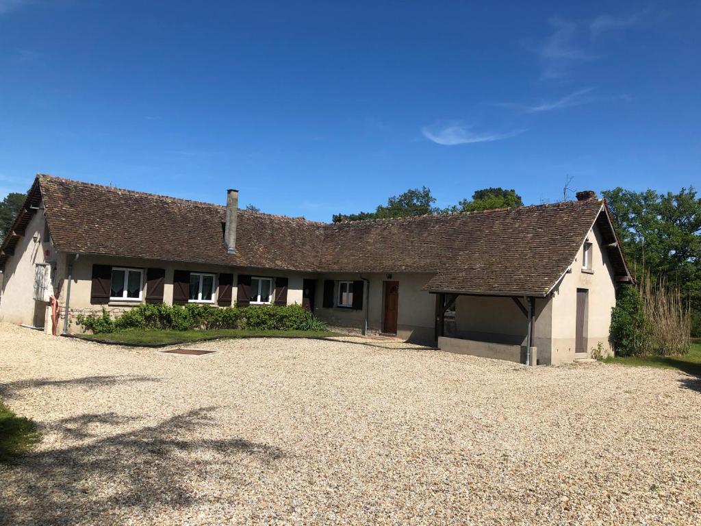 une maison avec une allée de gravier devant elle dans l'établissement DOMAINE NATURE Et SENS, à Presly