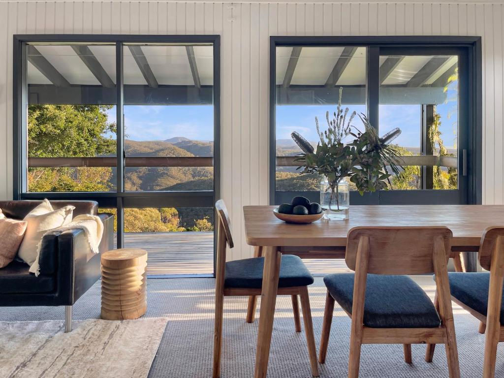 a dining room with a table and a view of the mountains at Clifftop cottage escape with breathtaking views in Wentworth Falls