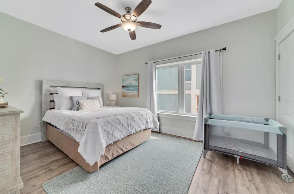 ein Schlafzimmer mit einem Bett und einem Deckenventilator in der Unterkunft Cozy Girls Summer Getaway! Bungalow w Private Beach! in Gulf Shores