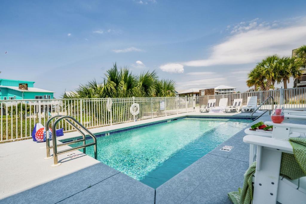 einen Pool in einem Resort mit einem Zaun in der Unterkunft Cozy Girls Summer Getaway! Bungalow w Private Beach! in Gulf Shores