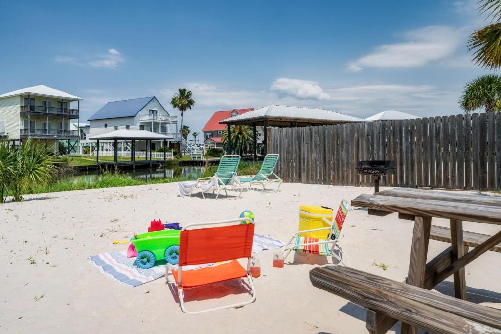 einen Strand mit Stühlen und einem Picknicktisch im Sand in der Unterkunft Cozy Girls Summer Getaway! Bungalow w Private Beach! in Gulf Shores