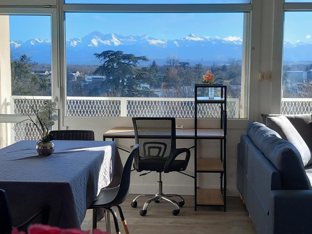 une pièce avec une table et des chaises et une grande fenêtre dans l'établissement Cap Sud - 53m2- VUE PYRENEES- HYPERCENTRE-WIFI FIBRE -Nouvelle literie, à Tarbes