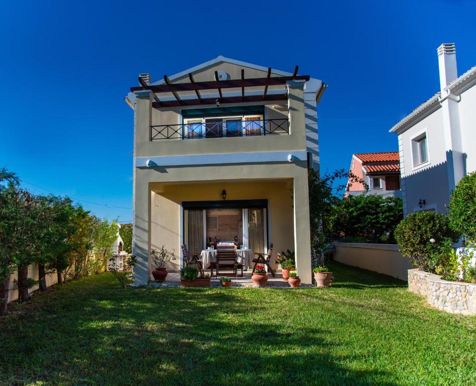 a large house with a lawn in front of it at Shell & Pebble in Acharavi