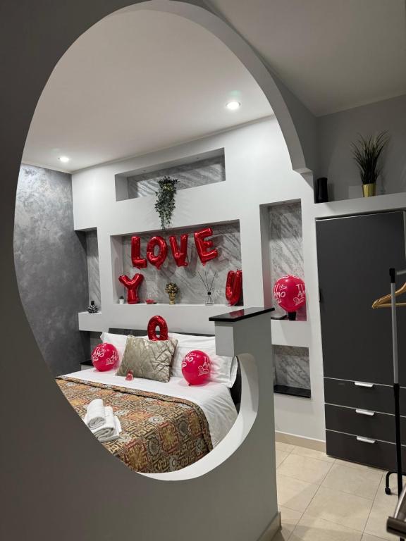 een kamer met een bed met een bord dat liefde zegt bij Il cortiletto28 Rooms & House in Siracusa
