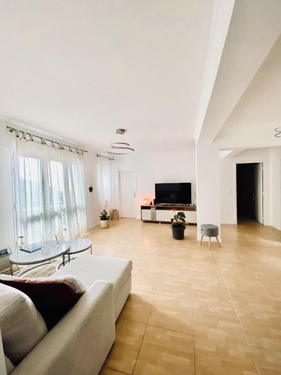 a large living room with a couch and a tv at Casa do sol in Santa Cruz
