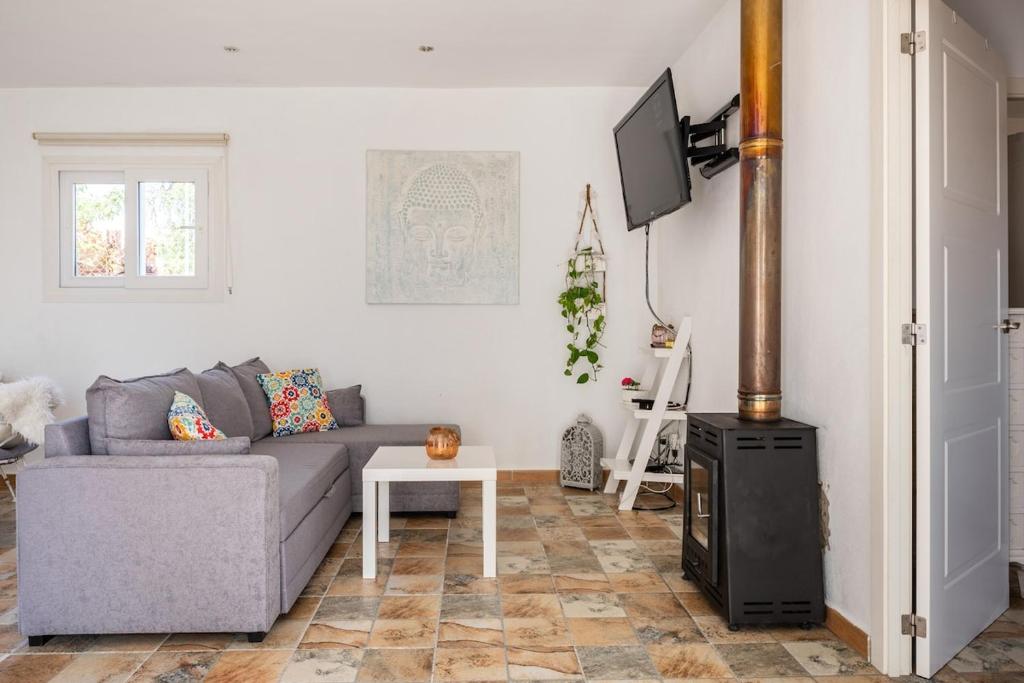 a living room with a couch and a tv at Sweet House in Islas Baleares