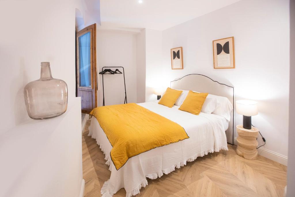 a bedroom with a bed with a yellow blanket at El Rincon de Marieta in Huesca