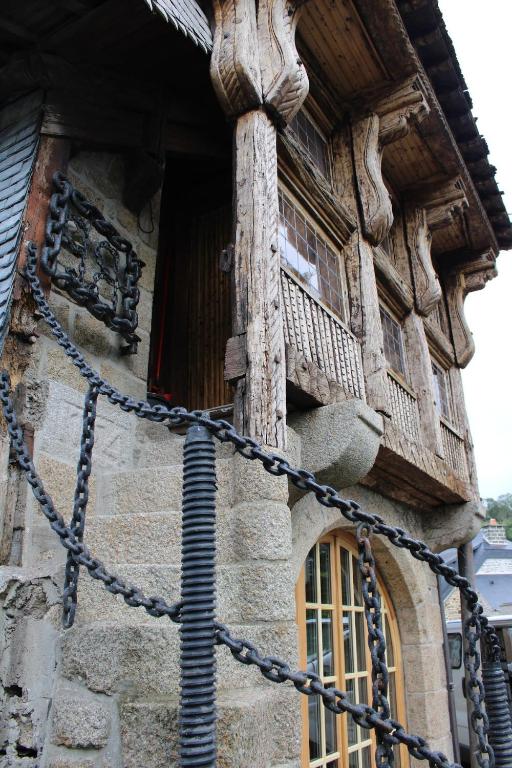 un vieux bâtiment avec une chaîne autour d'une fenêtre dans l'établissement Atypical apartment with a poudlard air, à Mont-Dol